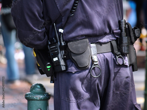 School Strike for Climate Action – A policeman wearing blue overalls, and a belt holding a radio and gun