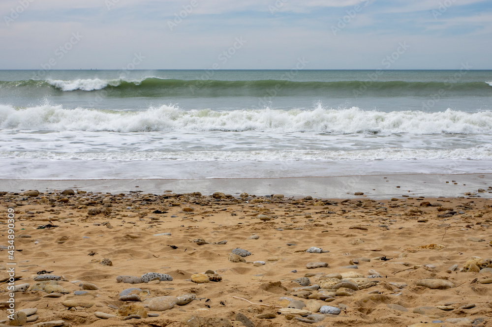 Vagues arrivant sur une plage de sable avec l'horizon en fond