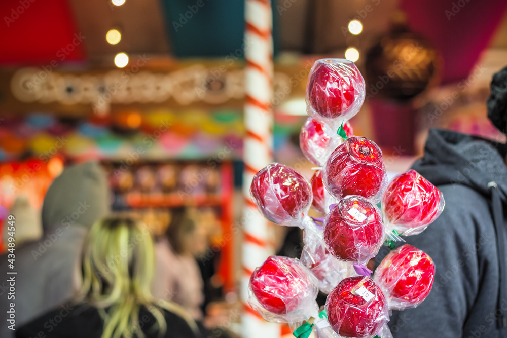 Fototapeta premium Wrapped toffee apples on display at Christmas market winter wonderland in London, England