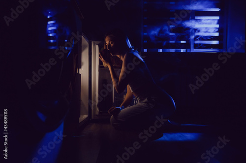 Hungry woman searching for food in refregerator late at night. © kanashkin