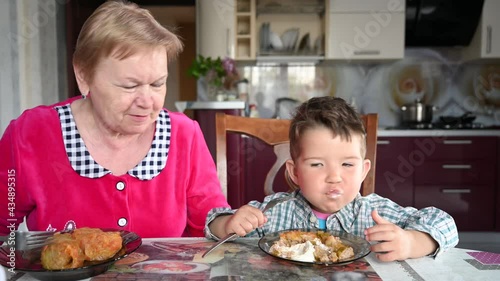 grandmother feeds her grandson in the kitchen