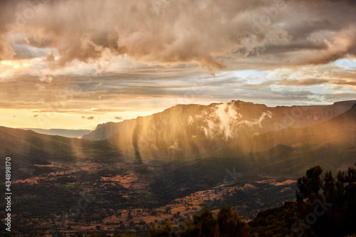 Aerial, dramatic view on illuminated rain over slopes of Bale mountains covered in Harenna forest, Ethiopia, Africa. Setting sun over Bale mountains national park. African nature. photo
