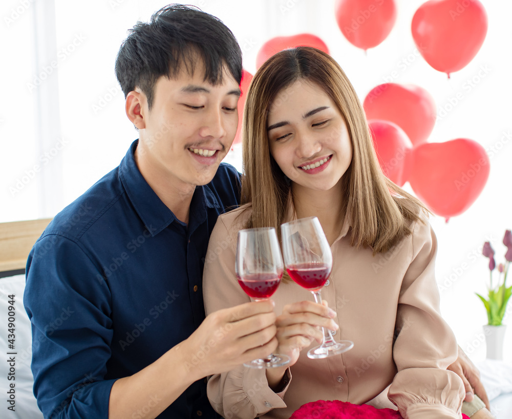 Happy Asian couple proposing toast during date
