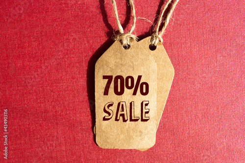 Big Offer 70% off price tag with brown string on red background