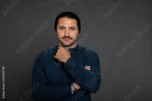 Portrait of smiling young hipster guy in hat and casual wear posing on isotaled grey background. Copy space. Concept of happy successful man, self-confidence, good offer, profession, freeelance work