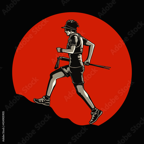 A silhouette of a trail runner running up the mountain On orange sunset background