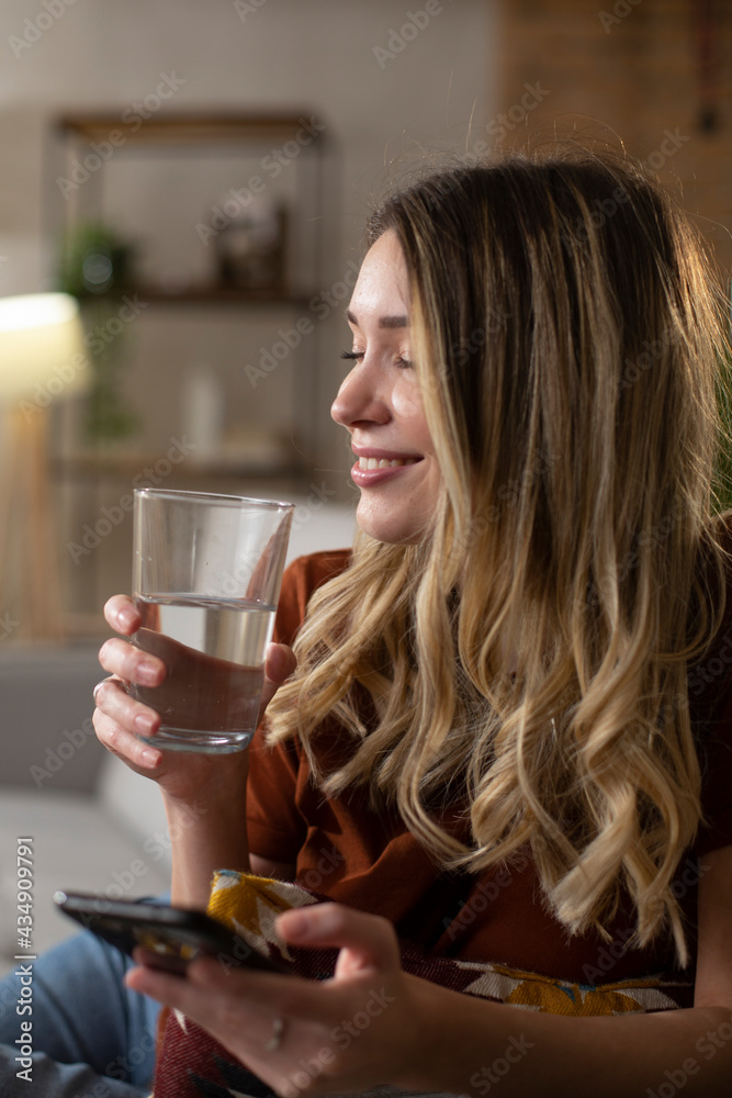 Girl holding a glass of water. Portrait of smiling girl drinking water..