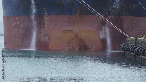 The ship dumps ballast water (discharging ballast water ) just off the coast. Such operations with liquid ballast lead to marine pollution photo