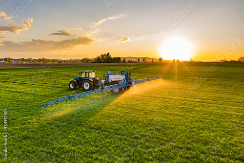 Farmer working in the field on a tractor until sunset.