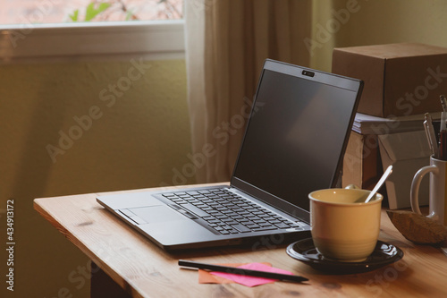 The home office  an example of a space for teleworking from home  where you can see a laptop and a cup of coffee or hot tea  early in the morning  in Madrid  Spain. Work-life balance.
