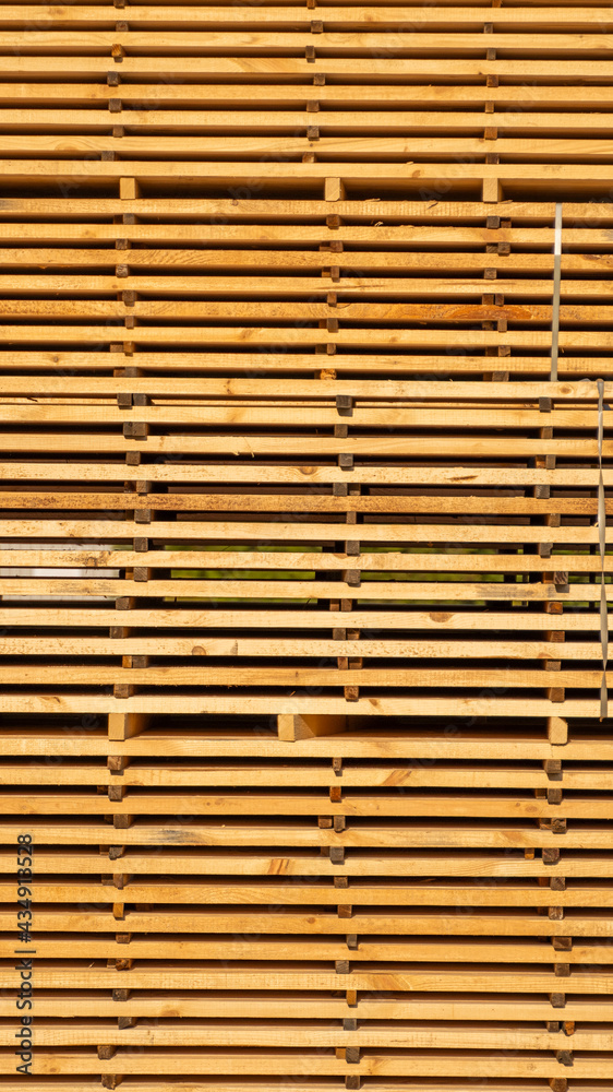 Storage of piles of wooden boards on the sawmill. Boards are stacked in a carpentry shop. Sawing drying and marketing of wood. Pine lumber for furniture production, construction. Lumber Industry.