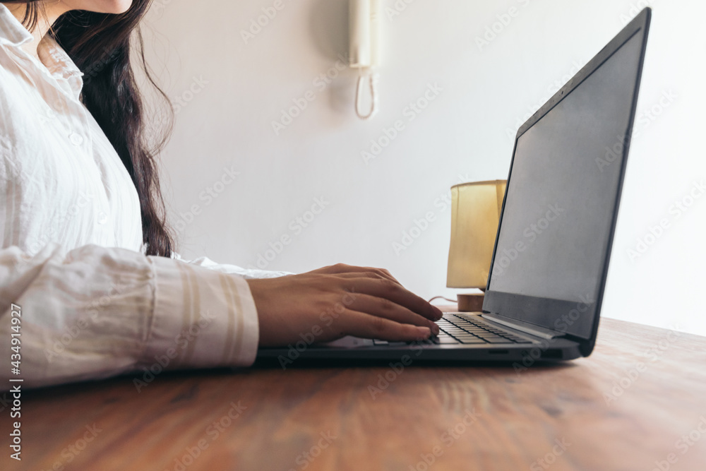 Fototapeta premium woman using her laptop in a desk. close-up. at home