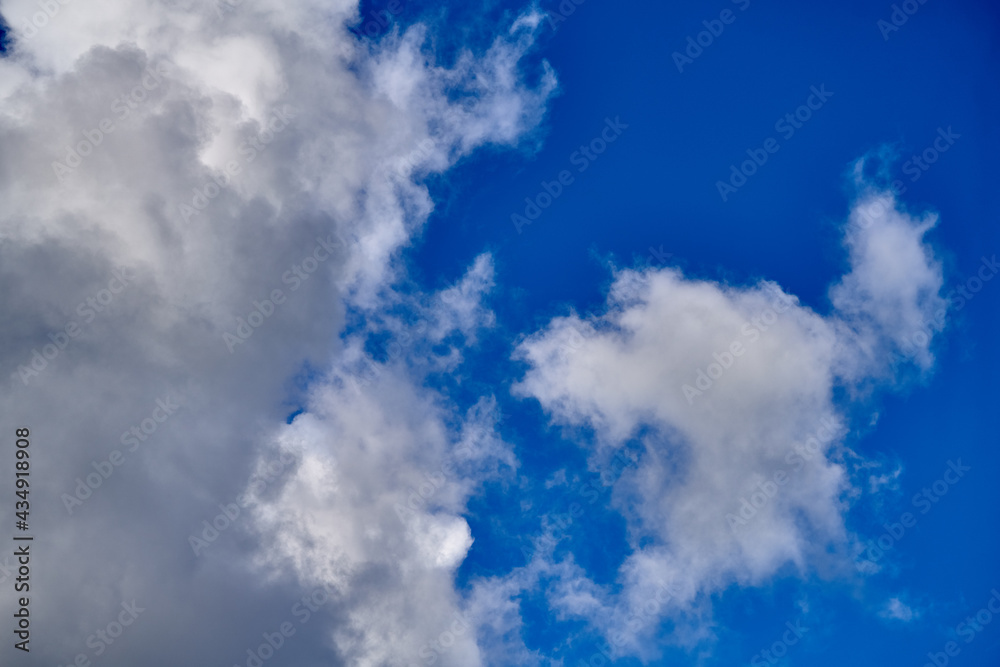 Fototapeta premium Dramatic thunderclouds float across the blue sky
