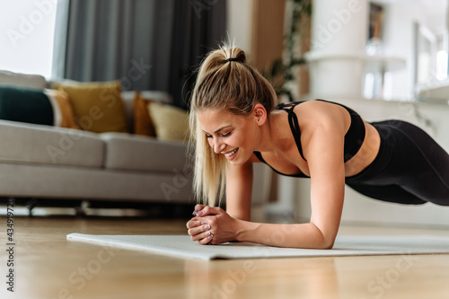 Sporty dressed female, doing workout at home.