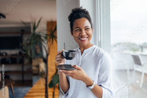 Happy black woman, enjoying in her cup of tea. photo
