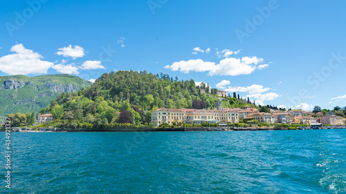 The famous cape with the beautiful village of Bellagio, Lake Como, Italy. View from the ferry-boat. Turquoise waters on the foregrouond. Blue sky on the background.