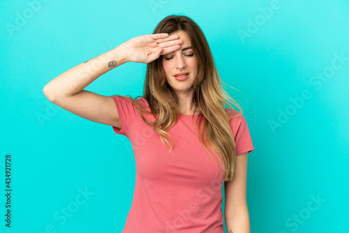 Young caucasian woman isolated on blue background with tired and sick expression