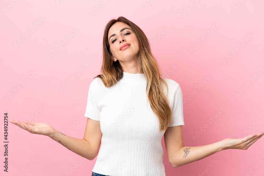 Caucasian woman isolated on pink background having doubts Caucasian woman isolated on pink background having doubts