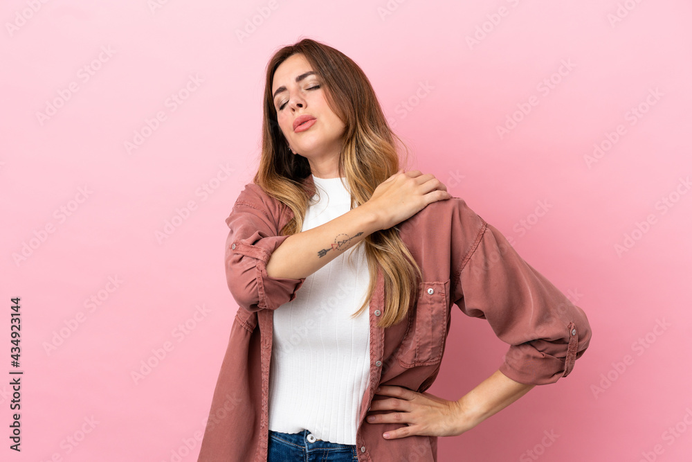 Caucasian woman isolated on pink background suffering from pain in shoulder for having made an effort Caucasian woman isolated on pink background suffering from pain in shoulder for having made an effort