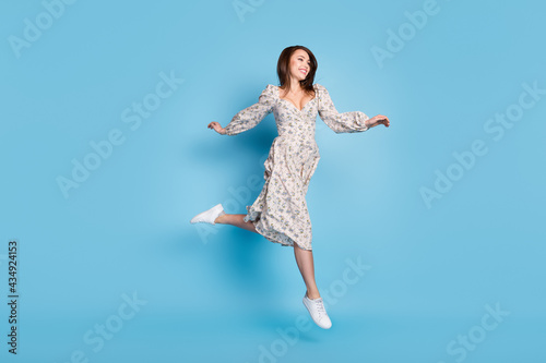 Full length photo of impressed brown hairdo young lady run wear dress isolated on blue background