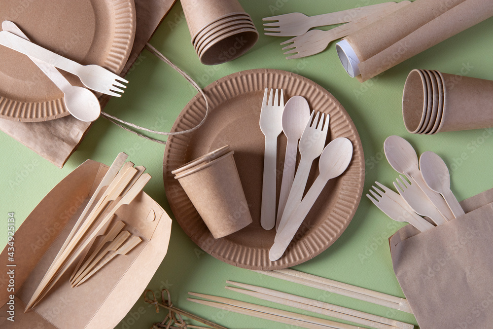 Disposable biodegradable tableware on craft paper plates - forks, spoons,  glasses, wooden and bamboo skewers, sushi sticks, parchment. Zero Waste.  View from above Stock Photo | Adobe Stock