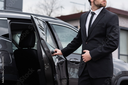 partial view of bearded bodyguard with security earpiece opening car door © LIGHTFIELD STUDIOS
