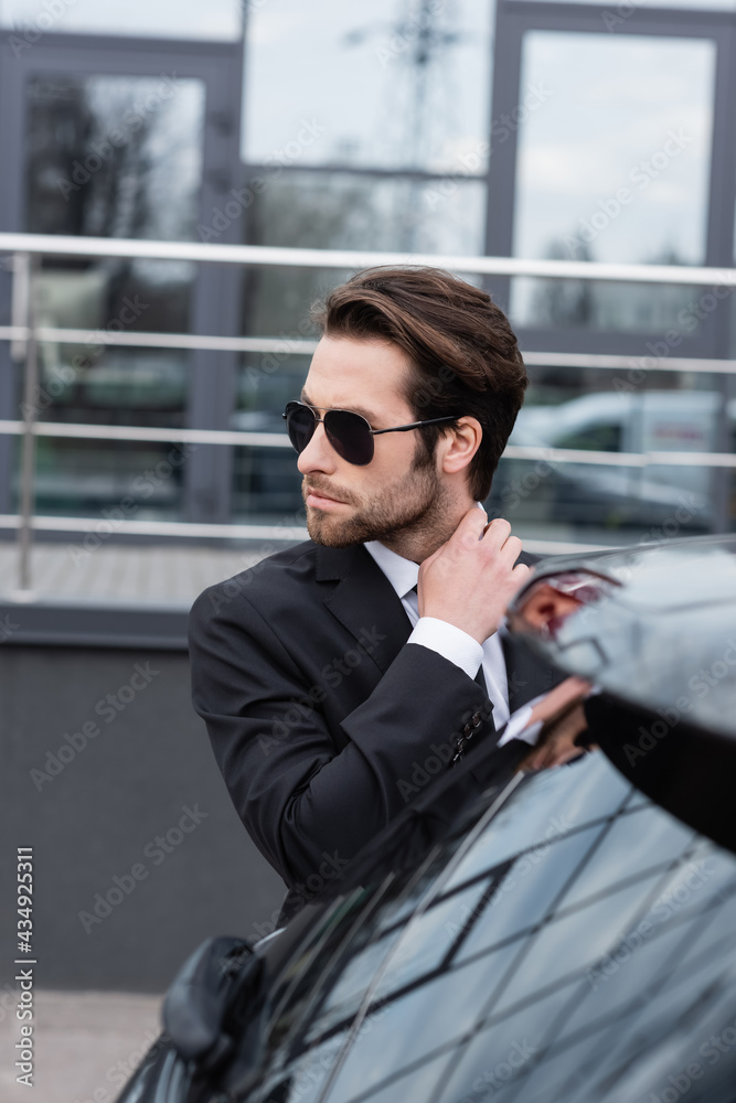 bearded man in suit and sunglasses near modern car bearded man in suit and sunglasses near modern car
