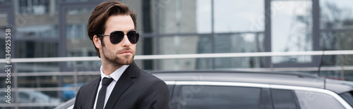 businessman in suit and sunglasses near modern car, banner © LIGHTFIELD STUDIOS