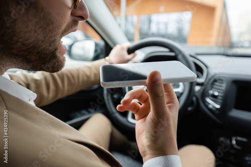 cropped view of bearded man recording voice message smartphone while driving car