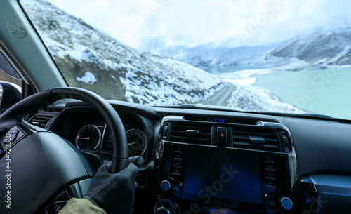 Driving off road car on snowing high altitude mountain trail on winter day