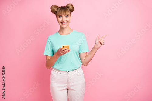Portrait of charming positive lady indicate finger empty space feedback tips isolated on pink color background