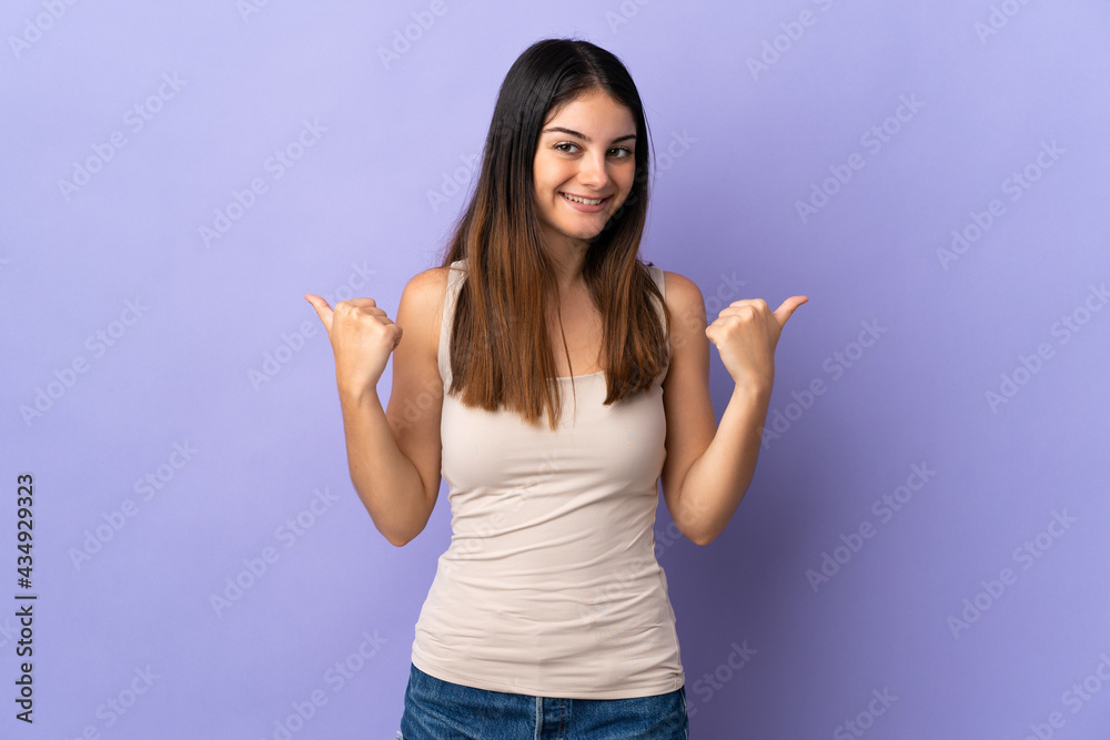 Young caucasian woman isolated on purple background with thumbs up gesture and smiling Young caucasian woman isolated on purple background with thumbs up gesture and smiling
