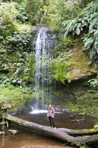  young woman standing in front of charming, Koropuku Falls is found in the western part of Catlins Conservation Park, along the scenic Chaslands Highway photo