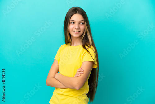 Little girl over isolated blue background with arms crossed and happy
