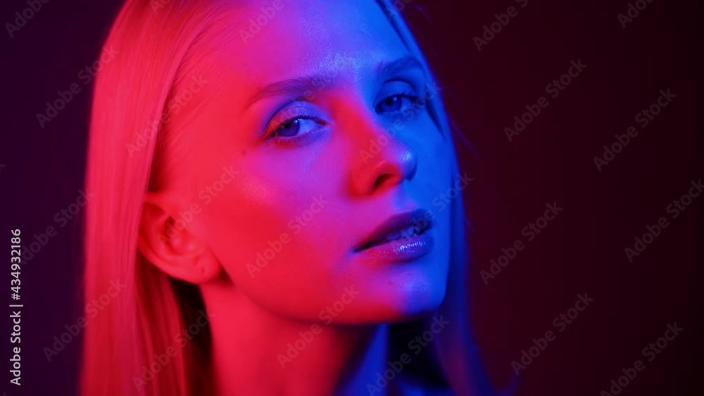 Woman Face with Open Eyes in Colourful Neon Light of Street Signs. Flickering Multi-Colour on Skin and Facial Features of Female. Close Shot of Urban Lady Woman Face with Open Eyes in Colourful Neon Light of Street Signs. Flickering Multi-Colour on Skin and Facial Features of Female. Close Shot of Urban Lady