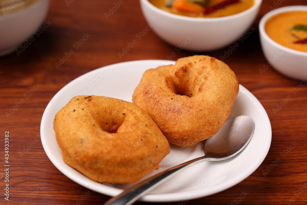 Medu Vada with tiffin sambar coconut chutney savoury fried snack of Kerala, Tamil Nadu South Indian India Sri Lanka . Top view of Indian vegetarian veg breakfast food. Lankan food.
Medu Vada with tiffin sambar coconut chutney savoury fried snack of Kerala, Tamil Nadu South Indian India Sri Lanka . Top view of Indian vegetarian veg breakfast food. Lankan food.