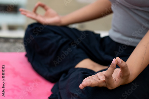 Close up a female hand with fingers in Gyan mudra symbol of wisdom  Indian girl practice yoga sitting in lotus pose