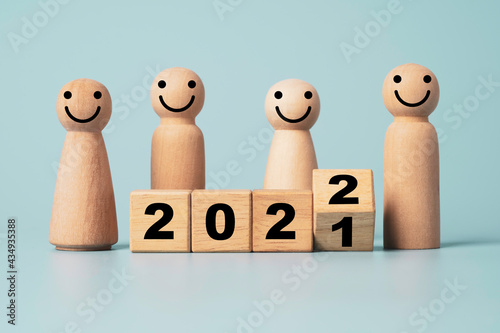 Flipping of wooden cube block for change 2021 to 2022 with wooden figure , Merry Christmas and Happy new year preparation.