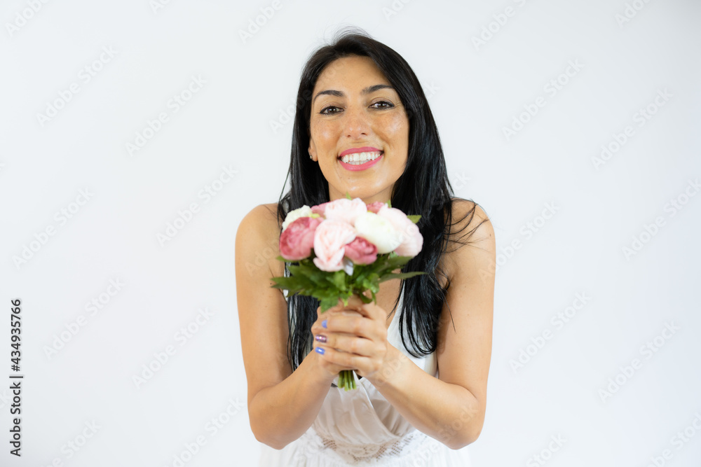 Beautiful smiling woman holding bouquet of flowers over white background Beautiful smiling woman holding bouquet of flowers over white background