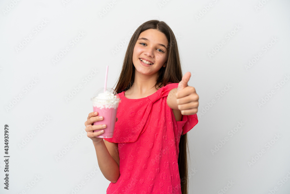 Little girl with strawberry milkshake over isolated white background with thumbs up because something good has happened Little girl with strawberry milkshake over isolated white background with thumbs up because something good has happened