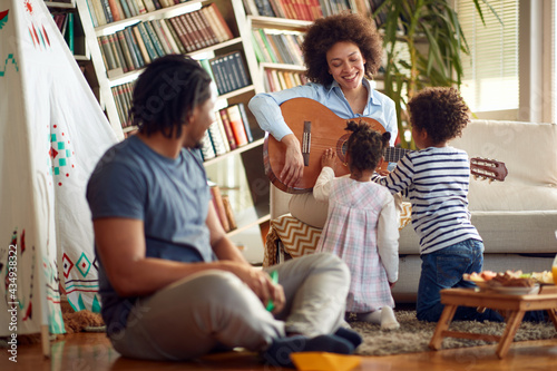Kids love when Mom plays the guitar at home. Family, together, love, playtime
