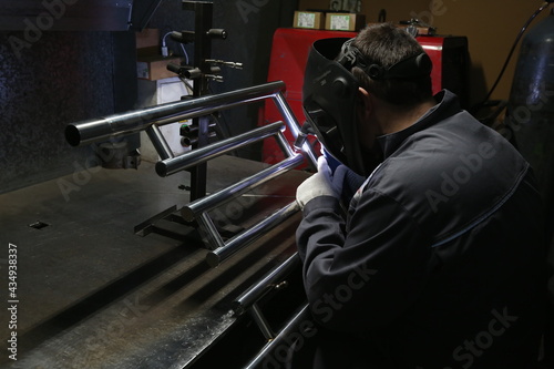 Welder at work at the factory for the production of towel rails
