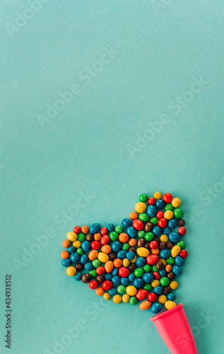Chocolate multicolored heart candy dragee on a blue background