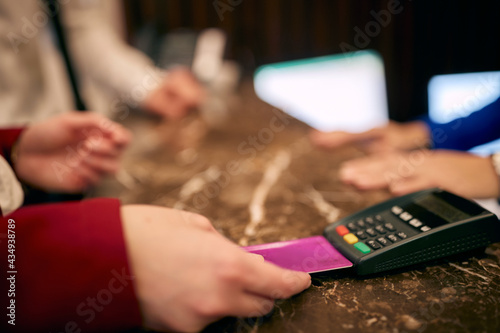 paying with credit card at hotel reception. detail, hands, credit card