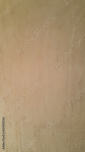 The plastered wall is brown. The wall inside the room. Background picture with scratches. Architecture and construction. Interior design. Copy space for text. Vertical position.