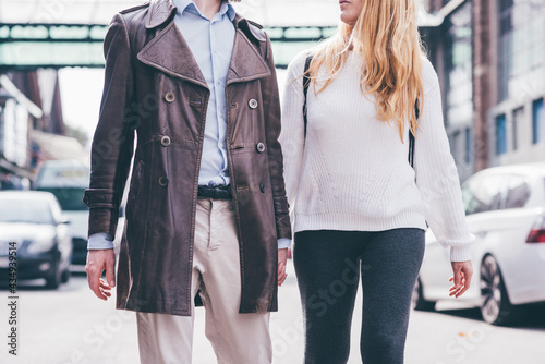 Middle section young couple walking outdoor hand in hand in love
