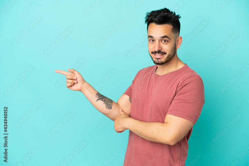 Young caucasian man isolated on blue background pointing finger to the side Young caucasian man isolated on blue background pointing finger to the side