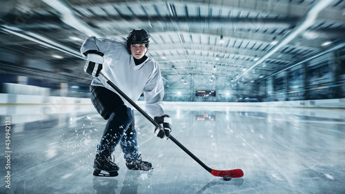 Professional male hockey player on ice court background. Caucasian fit athlete practicing, training excited