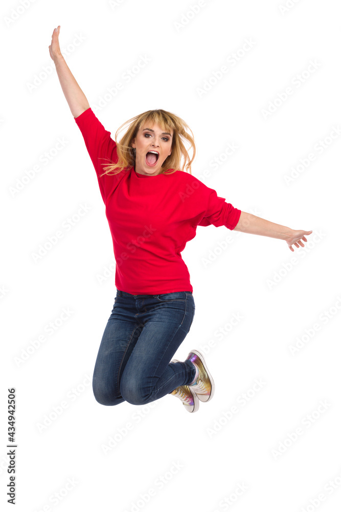 Young Woman Is Jumping With Arms Outstretched And Shouting