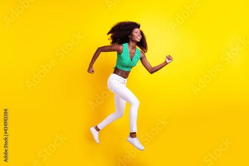 Full length body size photo woman jumping running on meeting late smiling isolated bright yellow color background